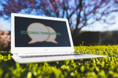 Laptop im Gras mit Eccelingo-Logo